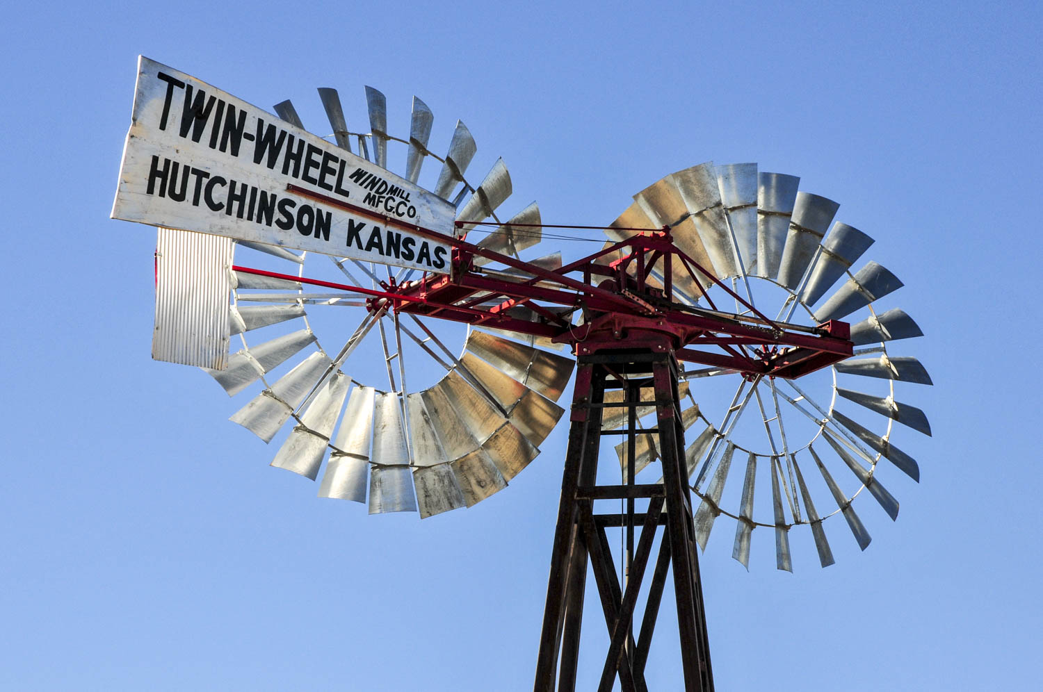 USA: Texas, Lubbock, Southern High Plains, American Wind Power Center and Windmill Museum, twin-wheel windmill for Huchinson Kansas, silhouetted against the sun