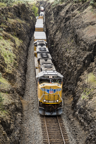USA:  Washington,  Columbia River Basin, Snake River Basin, Palouse Falls State Park, freight train going through dugout tunnel and under 1906 bridge