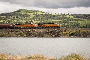 USA: Washington, Columbia River Basin,  BNSF freight train on Oregon side of Columbia River. east of Bingen, at river's edge