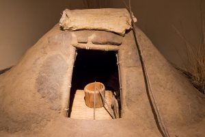 USA: Idaho,  Columbia River Basin, Snake River Basin, Lewiston, Nez Perce National Historic Park Visitor”s Center, mud hut used as sweat lodge with  wooden bucket
